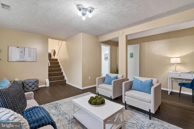a living room with furniture a rug and a lamp