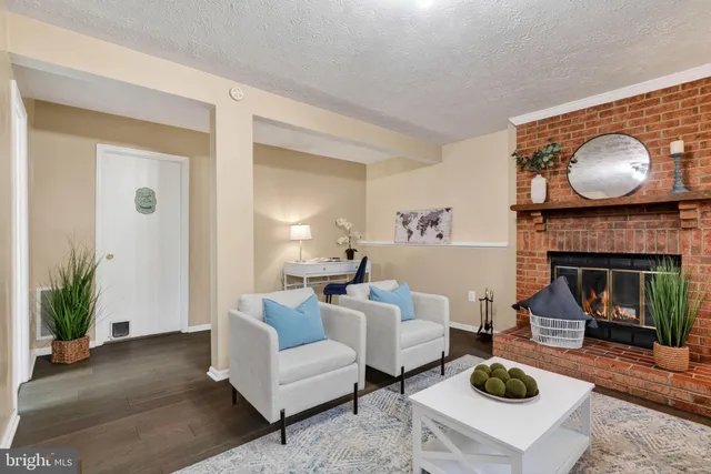 a living room with furniture a fireplace and a potted plant