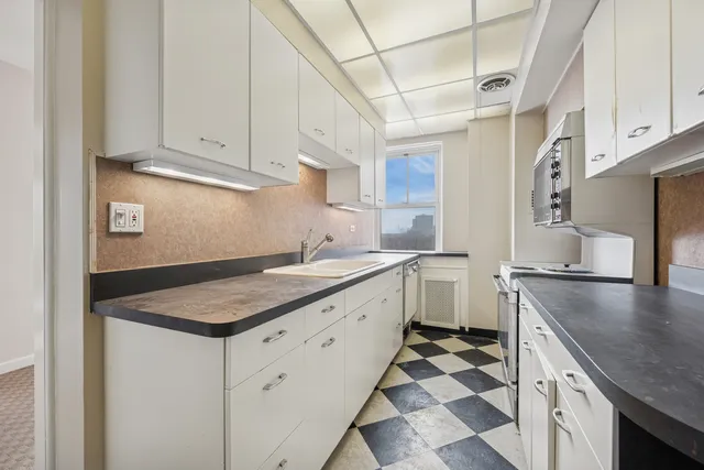 a kitchen with granite countertop a sink stove and cabinets
