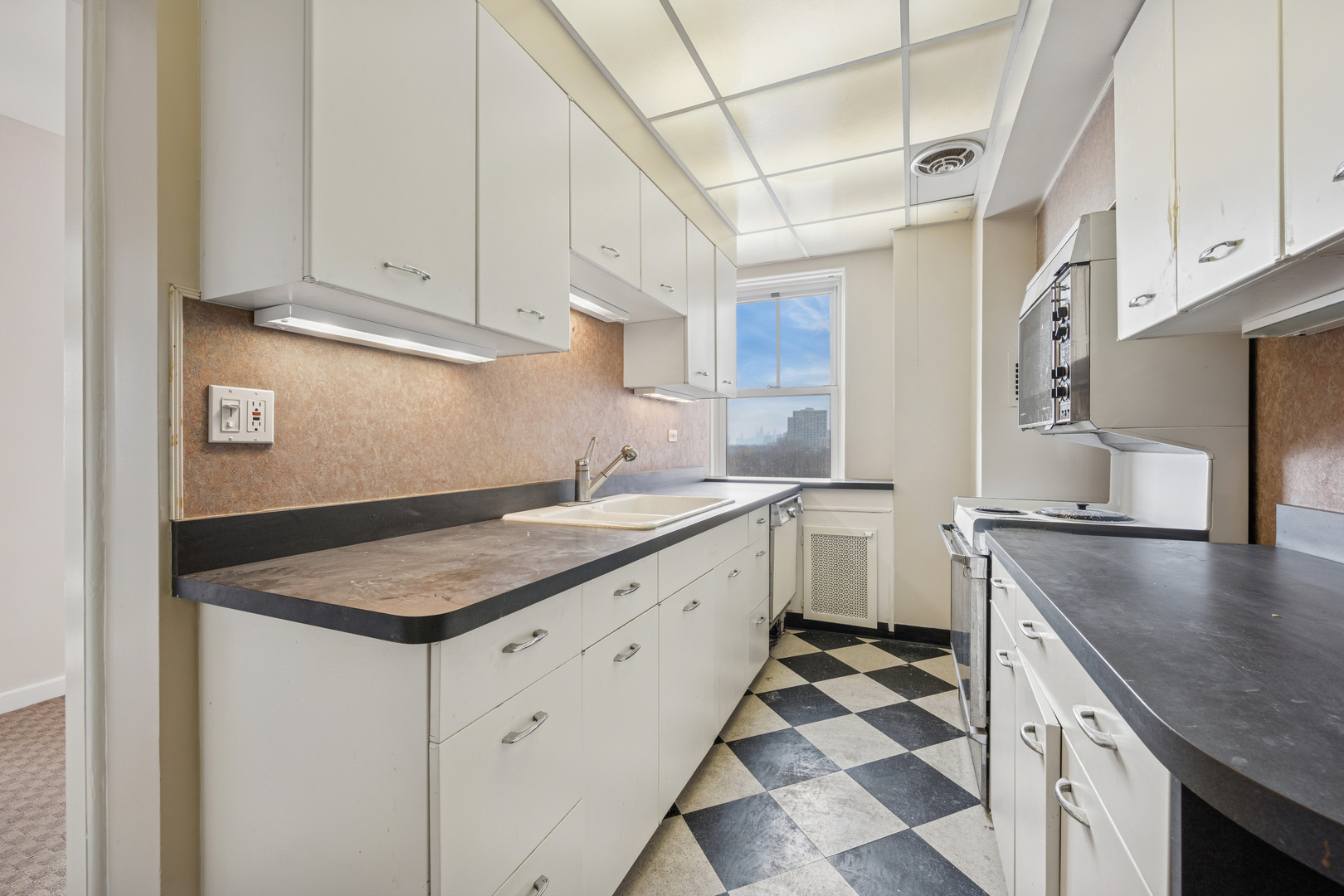 5555 North Sheridan Road, Unit 602 Chicago, IL 60640 - Photo 8 of 20 a kitchen with granite countertop a sink stove and cabinets
