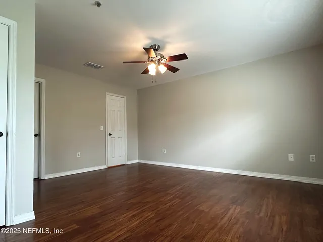 a view of an empty room with wooden floor