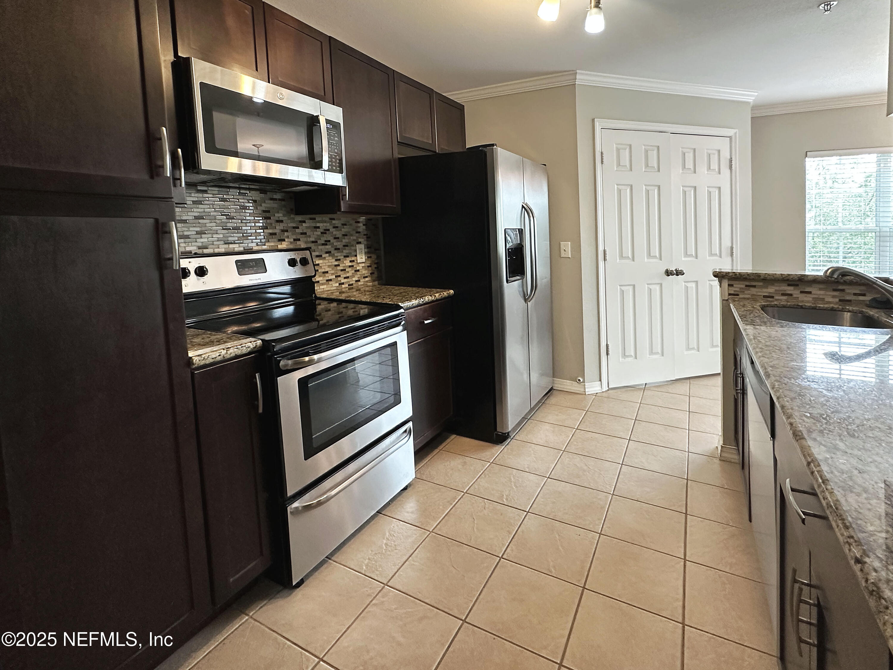 7800 Point Meadows Drive, Unit 631 Jacksonville, FL 32256 - Photo 8 of 26 a kitchen with stainless steel appliances granite countertop a stove a microwave and a refrigerator
