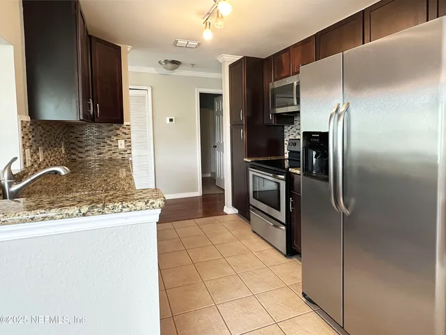 a kitchen with stainless steel appliances granite countertop a refrigerator and a sink