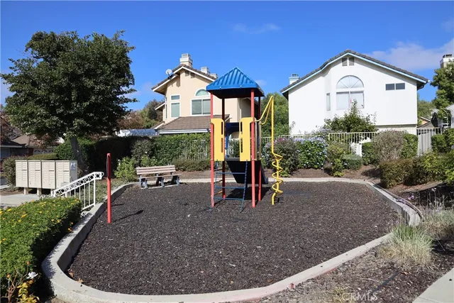 a view of a house with a small yard and sitting area