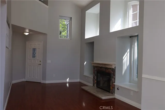 an empty room with windows and fireplace