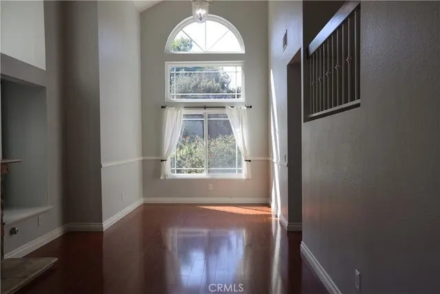 a view of empty room with window and wooden floor
