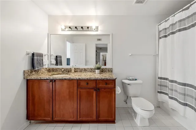 a spacious bedroom with a bed a chandelier and a window