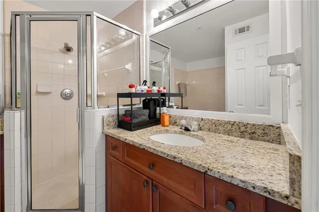 a bathroom with a granite countertop sink mirror and a bath tub