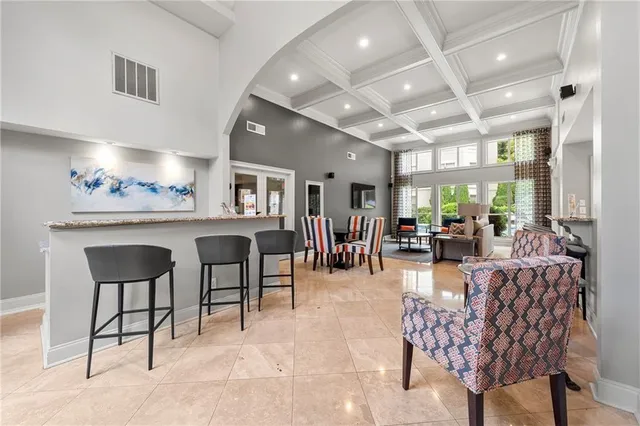 a living room with furniture kitchen view and a wooden floor