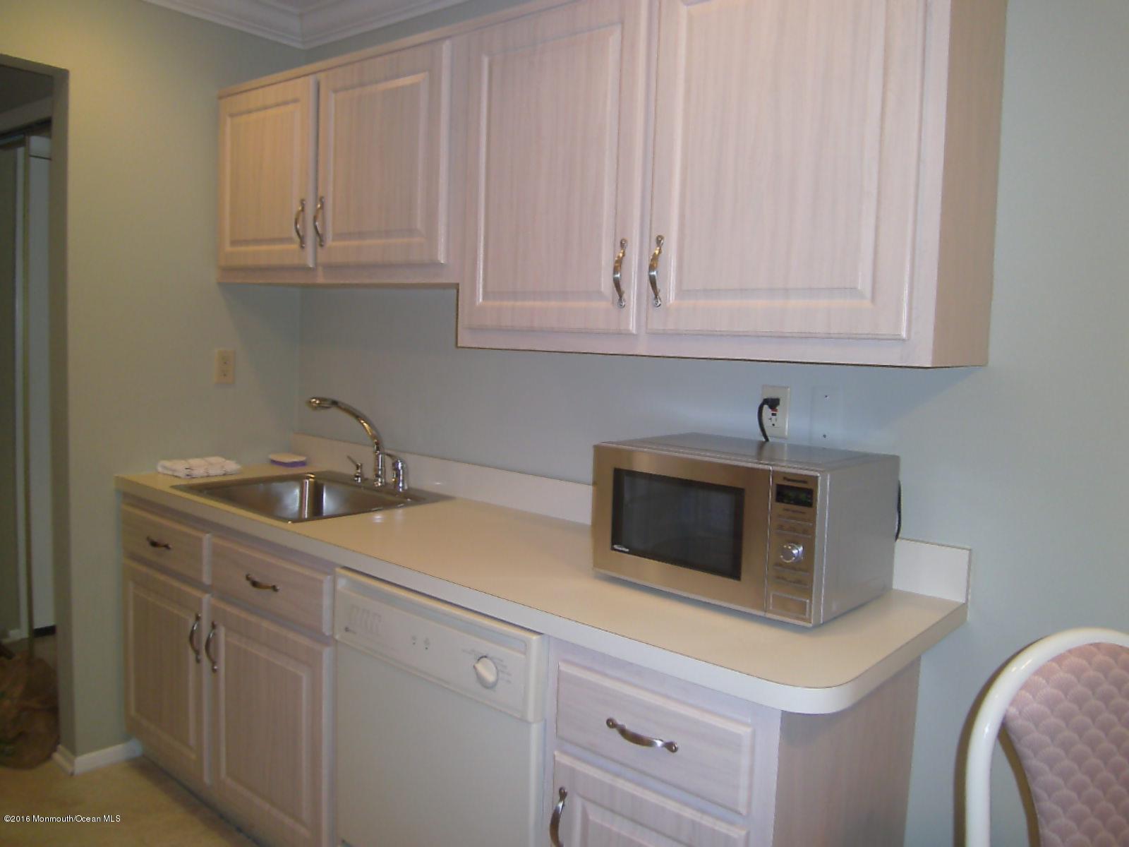 30 Meadow Green Circle, Unit E Manalapan, NJ 07726 - Photo 2 of 11 a kitchen with white cabinets and sink