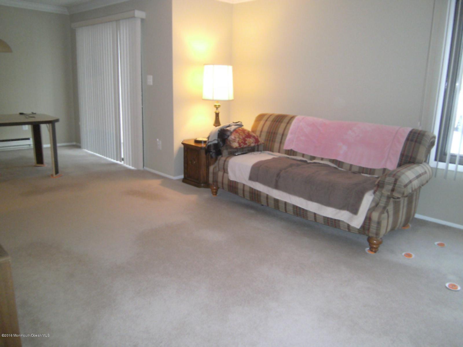 30 Meadow Green Circle, Unit E Manalapan, NJ 07726 - Photo 4 of 11 a bedroom with a bed and a couch