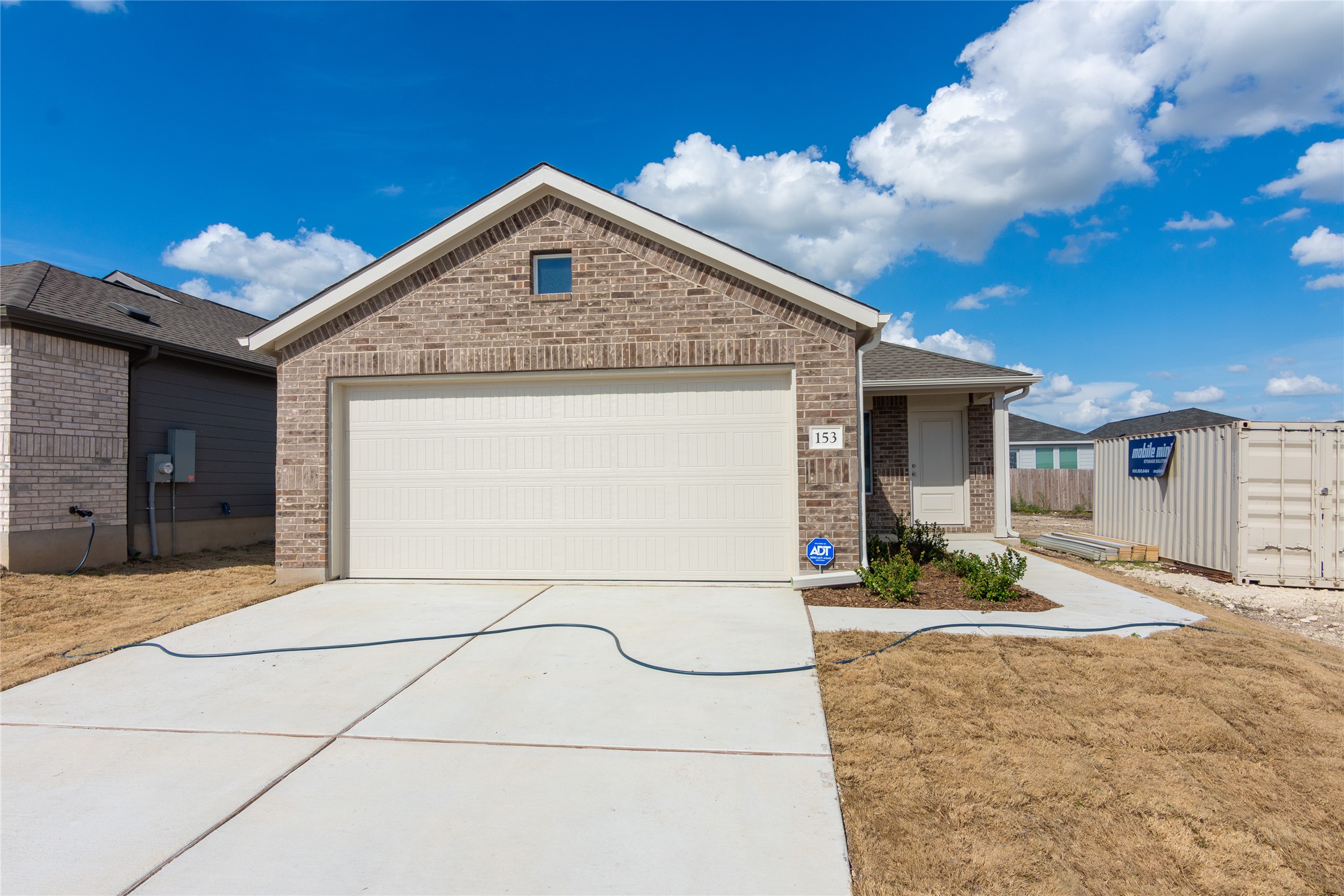 153 Star Packer Lane Jarrell, TX 76537 - Photo 4 of 30 A classic brick exterior and attached garage with a concrete driveway welcome you home.