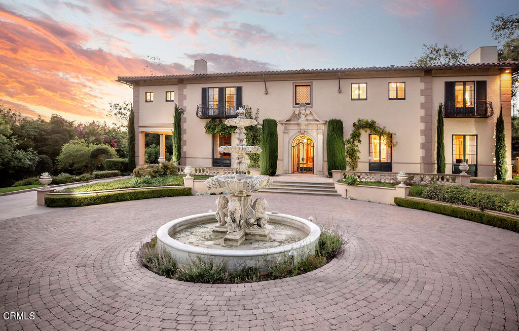 a view of a house with fountain in front of house