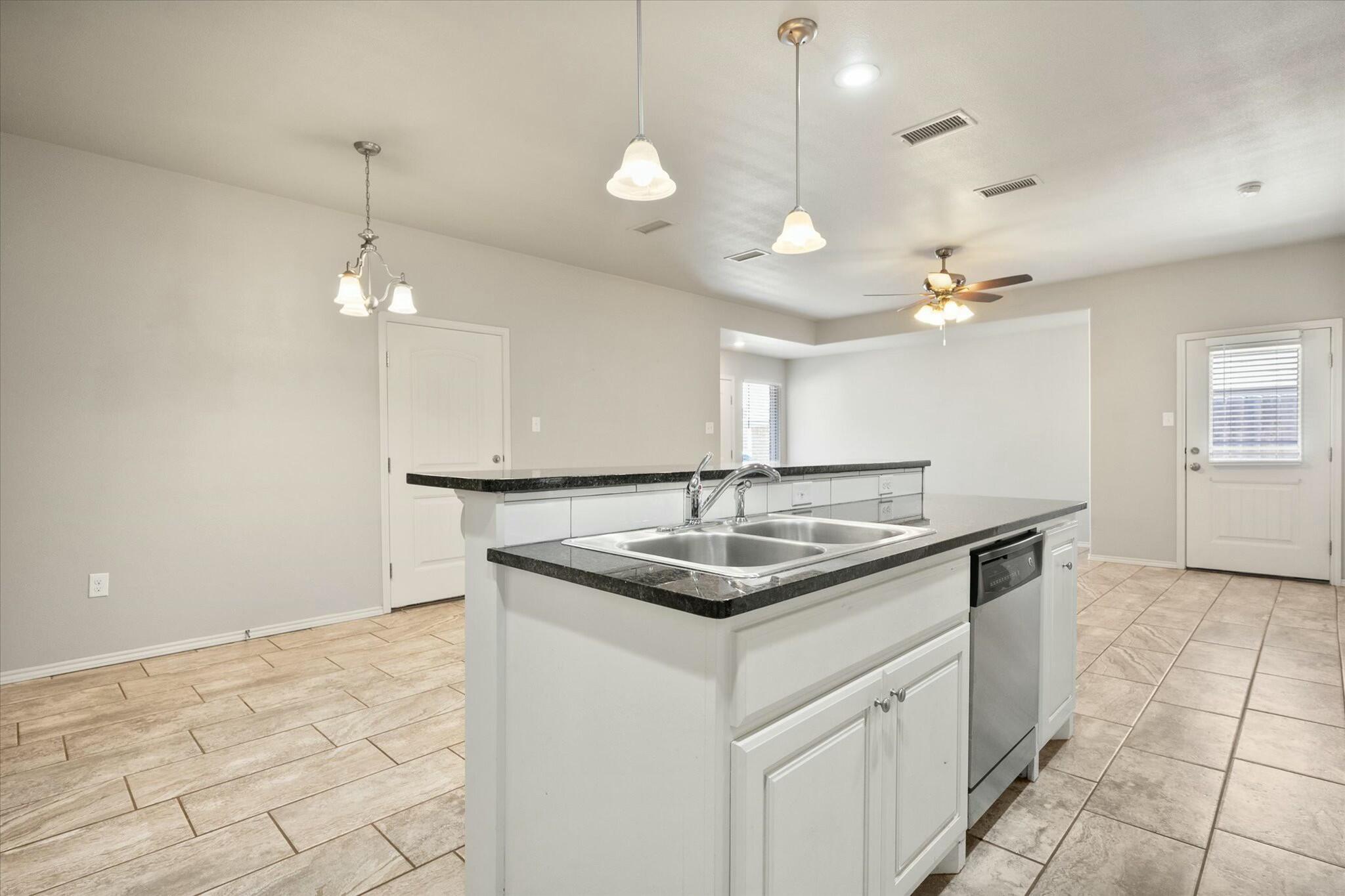 2619 113th Street Lubbock, TX 79423 - Photo 16 of 31 a kitchen with a sink and chandelier