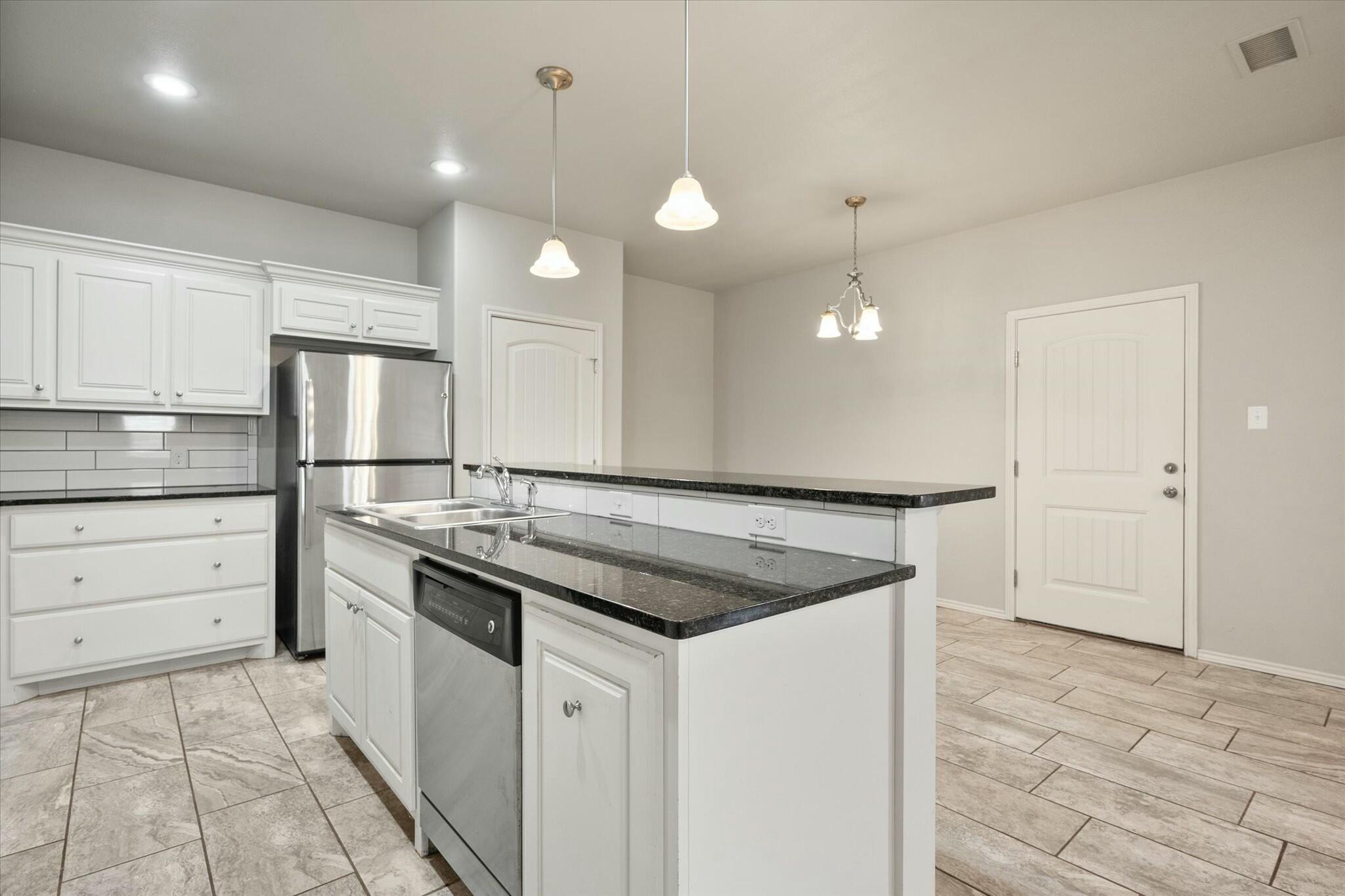 2619 113th Street Lubbock, TX 79423 - Photo 17 of 31 a kitchen with a sink stove and refrigerator