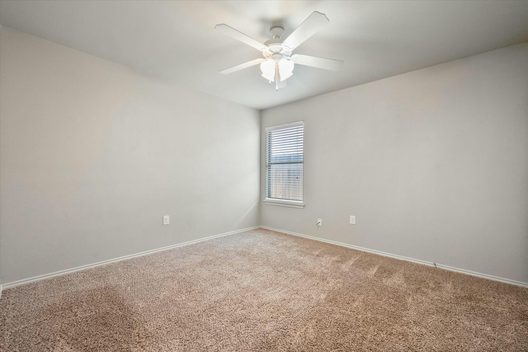 2619 113th Street Lubbock, TX 79423 - Photo 19 of 31 an empty room with windows and chandelier fan