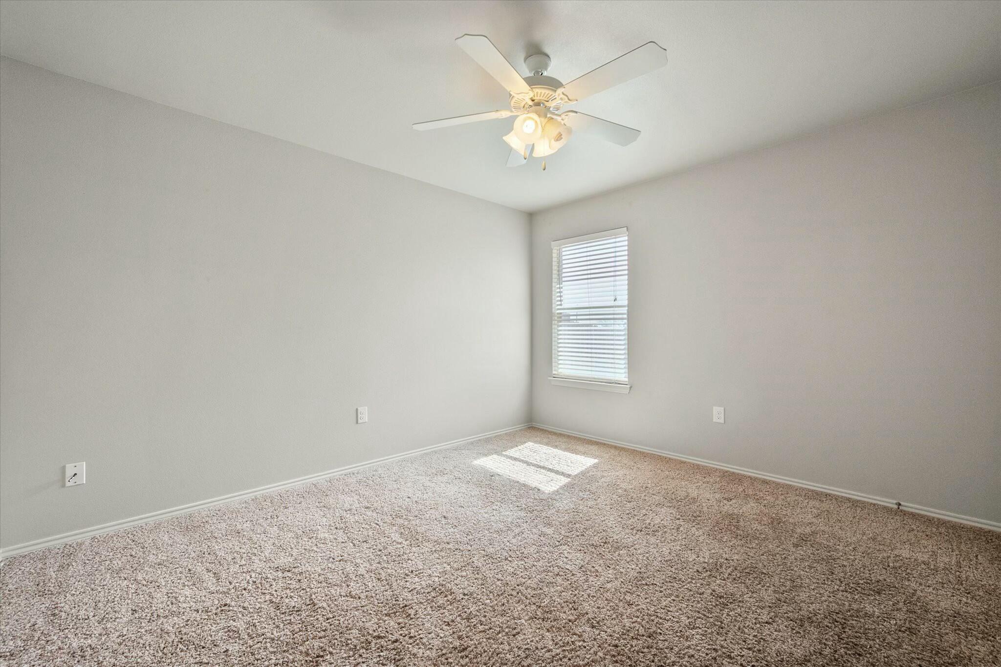 2619 113th Street Lubbock, TX 79423 - Photo 22 of 31 an empty room with a chandelier fan and windows