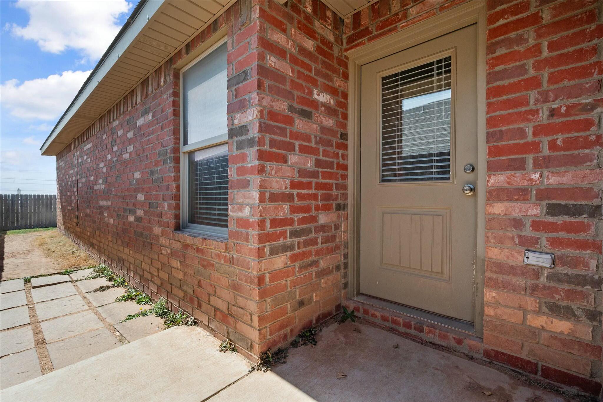 2619 113th Street Lubbock, TX 79423 - Photo 29 of 31 a view of a brick house with a door