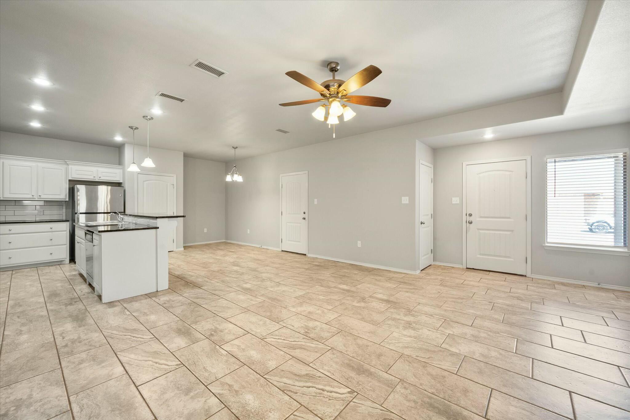 2619 113th Street Lubbock, TX 79423 - Photo 8 of 31 a view of a kitchen with a refrigerator and a stove top oven