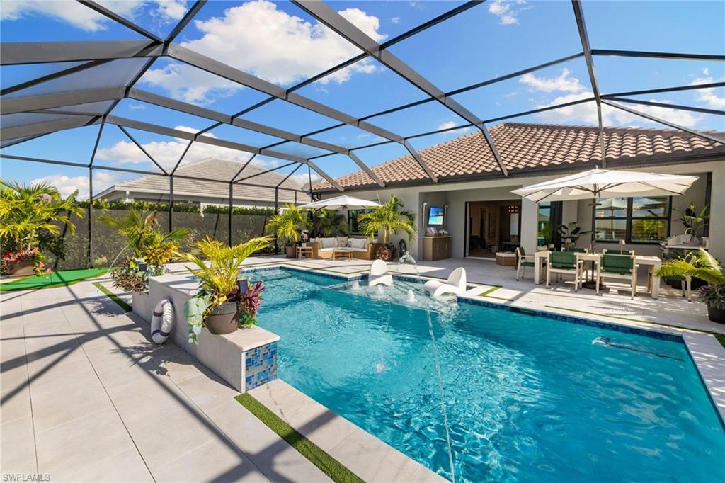 3967 Pegasus Way Naples, FL 34120 - Photo 30 of 50 a view of a patio with table and chairs under an umbrella