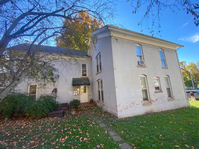 a yellow house with trees in front of it
