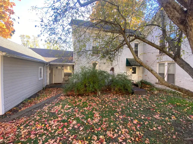 a view of a grey house with a yard