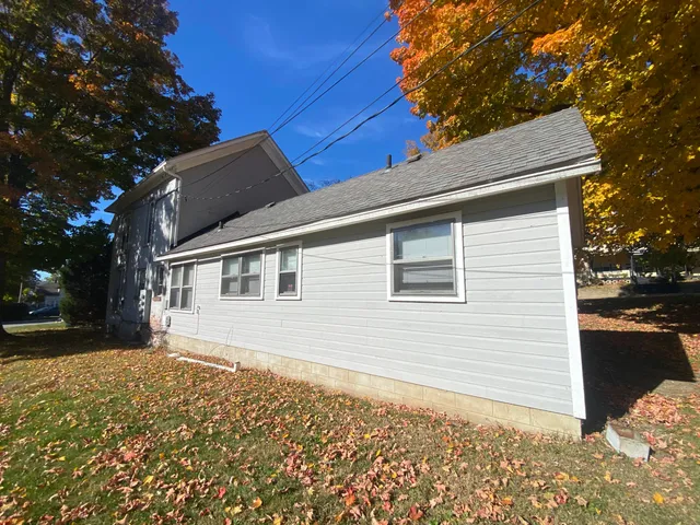 a view of a house with a yard and large tree