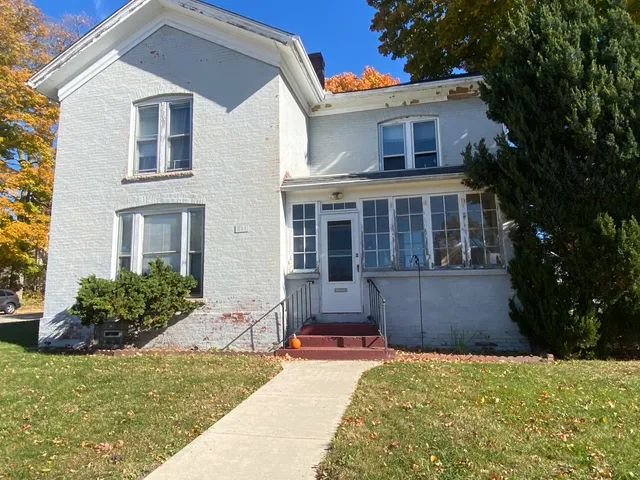 a view of empty room with wooden floor and window