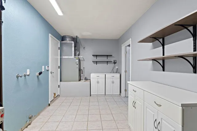 a kitchen with a refrigerator a stove top oven and cabinets