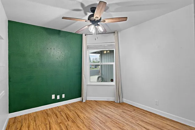 a view of a livingroom with a chandelier fan and hardwood floor