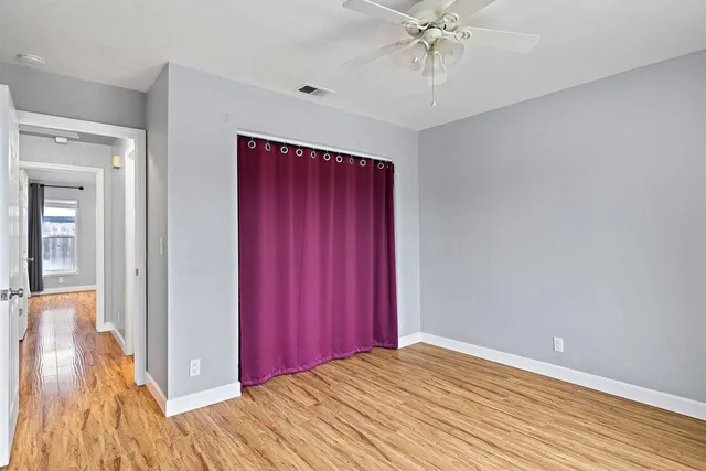 a view of a livingroom with wooden floor and a ceiling fan