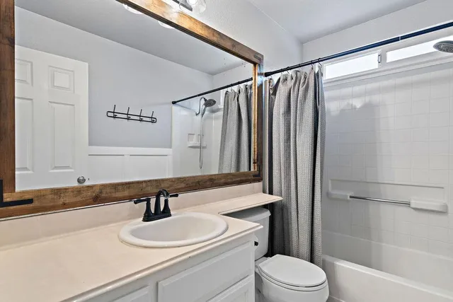 a bathroom with a sink a toilet and a mirror