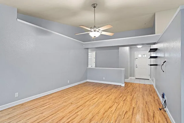 a view of a room with a ceiling fan and a hardwood floor