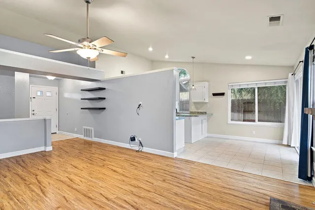 a view of a kitchen with wooden floor and a ceiling fan