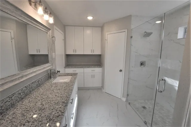 a view of a kitchen with white cabinets