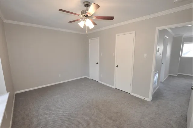 an empty room with a ceiling fan and a window