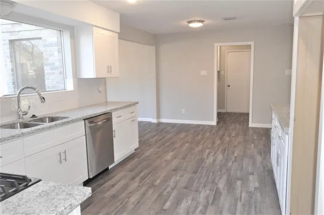 a room with a sink cabinets and wooden floor
