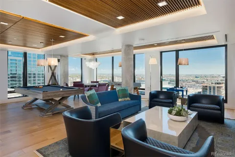 a living room with furniture a rug and a ceiling fan