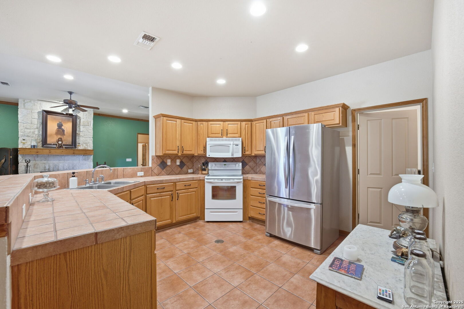 805 Paddy Road Floresville, TX 78114 - Photo 11 of 26 a kitchen with a refrigerator and a sink