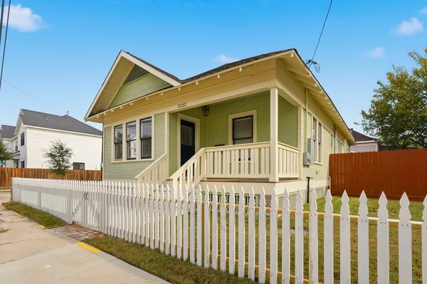 a view of a house with wooden fence