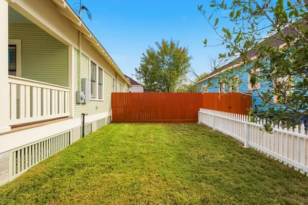a view of backyard with wooden fence and trees