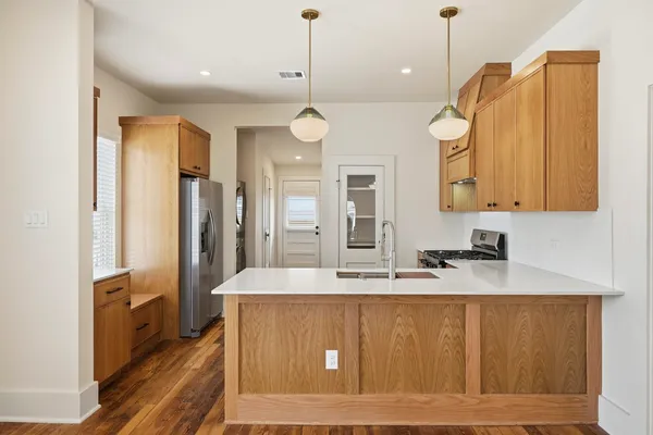 a large kitchen with stainless steel appliances granite countertop a sink a refrigerator and a granite counter tops