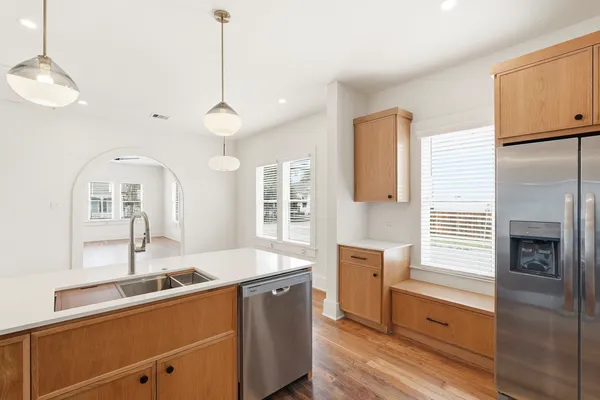 a kitchen with stainless steel appliances a sink stove and wooden floor