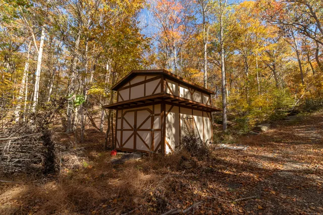 a view of a wooden house with large trees
