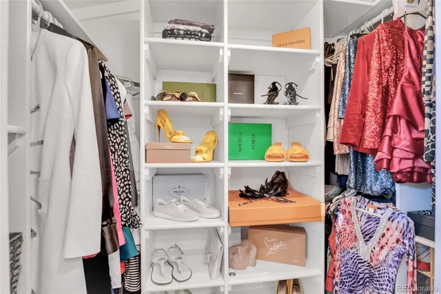 a view of walk in closet with clothes and shoes