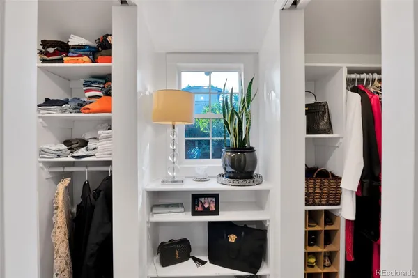 a view of walk in closet with clothes and shoes