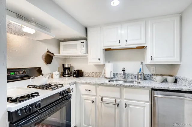 a kitchen with stainless steel appliances granite countertop a sink stove and cabinets