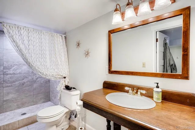 a bathroom with a sink a toilet and a mirror