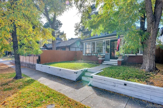 a view of a backyard with a large tree and wooden fence