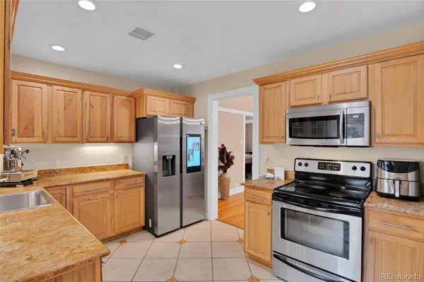 a kitchen with stainless steel appliances granite countertop a stove a refrigerator and a microwave